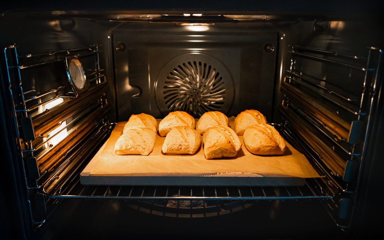 Baking Stone With Bread Rolls In Oven