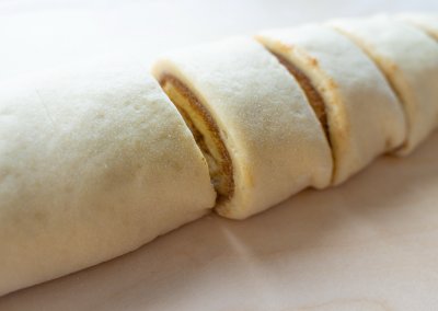 Homemade Cinnamon Rolls Cutting Dough Into Pieces